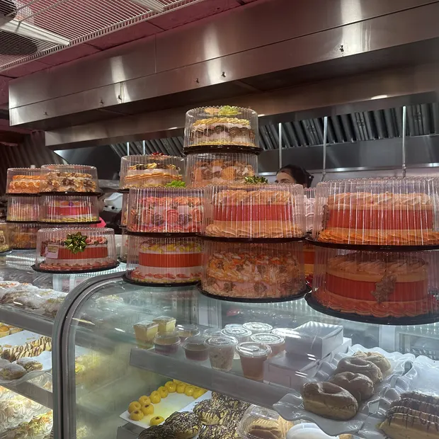 Vitrina con cakes de varios pisos y bandejas de dulces