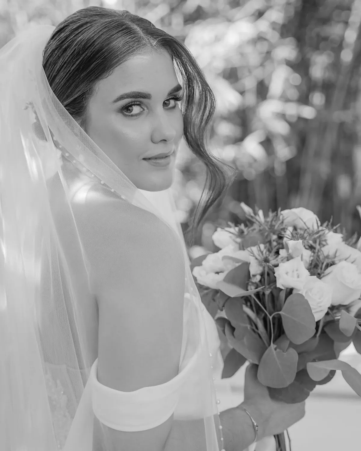 Black and white portrait of the bride with her veil and bouquet