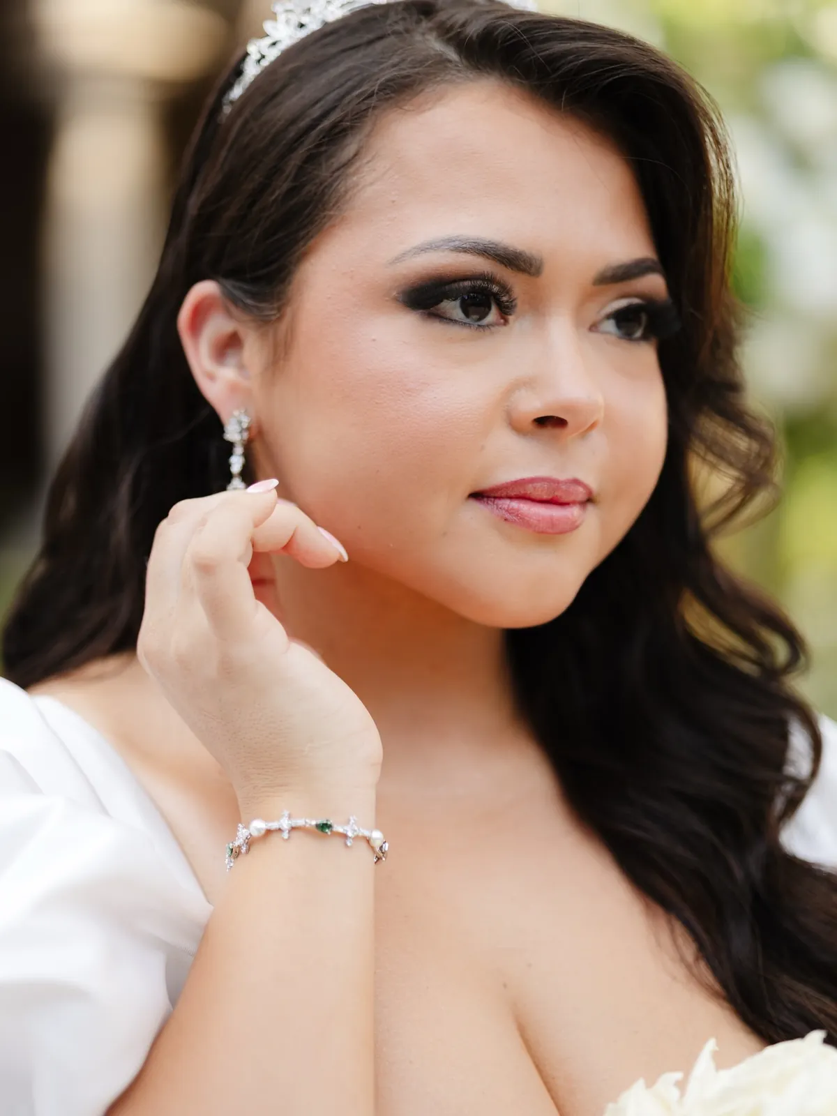 Close portrait of the bride in a jewelled tiara and drop earrings