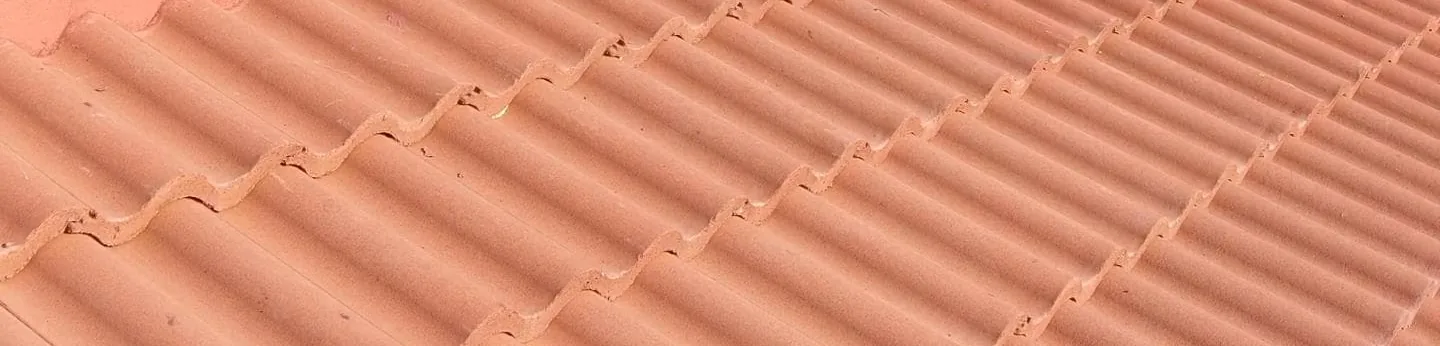 Close view of new clay roof tiles laid in diagonal rows.