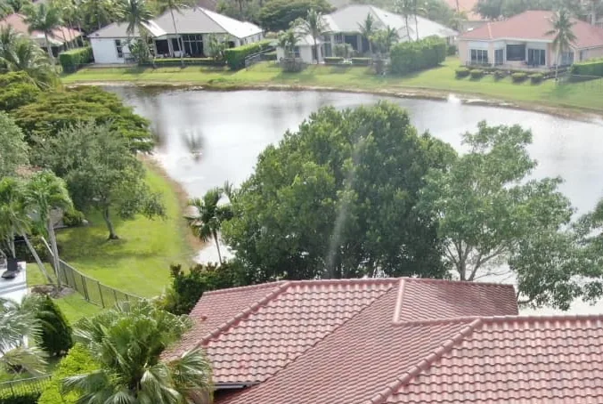Clay tile roof finished on a house with a lake behind it.